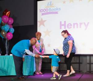 Robert Lambert and Carol Hill Evans present Henry and Andrea Nye with their 1000 Books Before Kindergarten Certificate of Completion