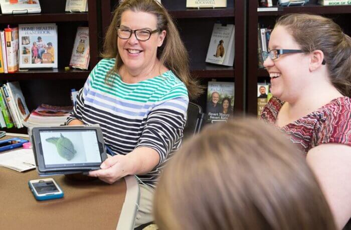 Adult Woman Showing Tablet To Friends