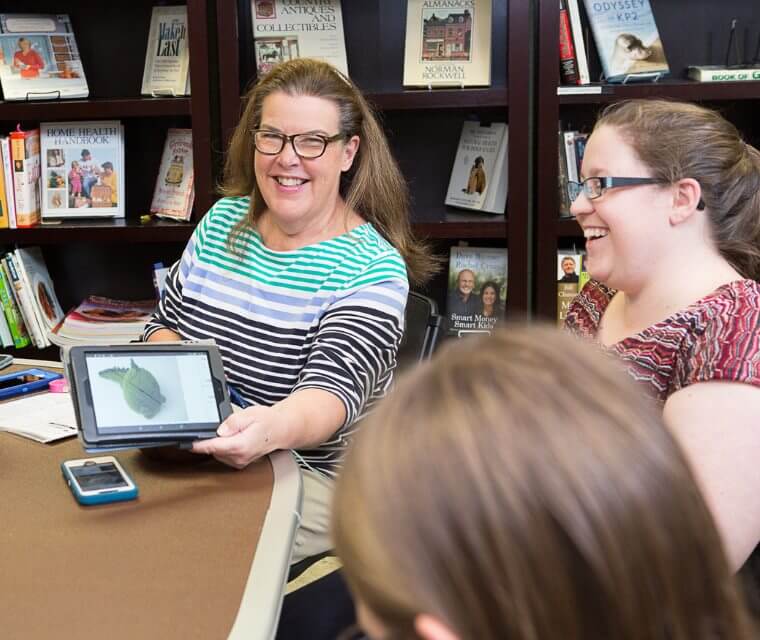 Adult Woman Showing Tablet To Friends
