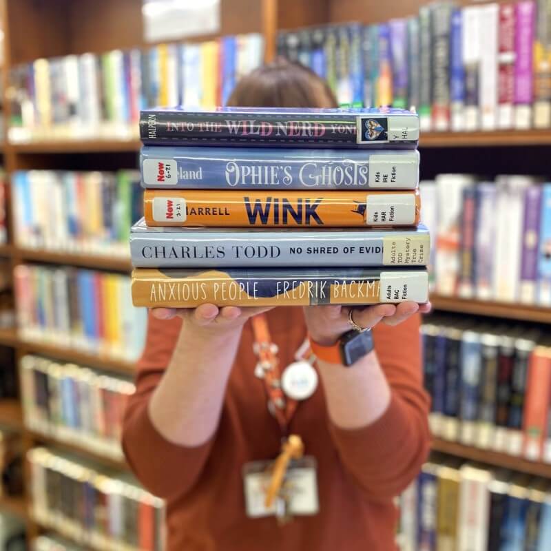 Staff Holding Stack Of Books Booklists Sidebar