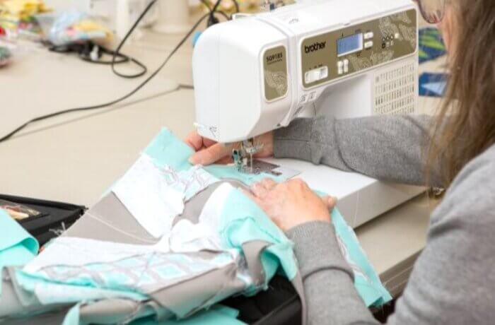 close up of hands using sewing machine