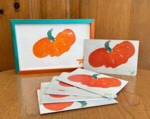 Photo of the art piece "The Perfect Pumpkin" and postcard prints of the piece.