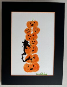 Photo of the piece "Seasonal Sneeze" which features a stack of orange pumpkins and a black cat