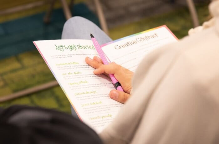Teen holding a workbook at Part of the Story 2024