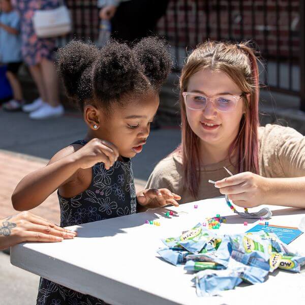 Girl learning a craft at Martin Library's block party