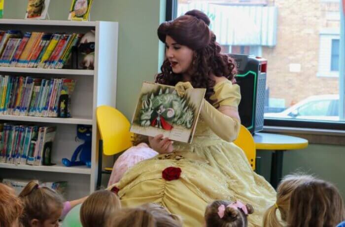 Princess performer reading a book to children