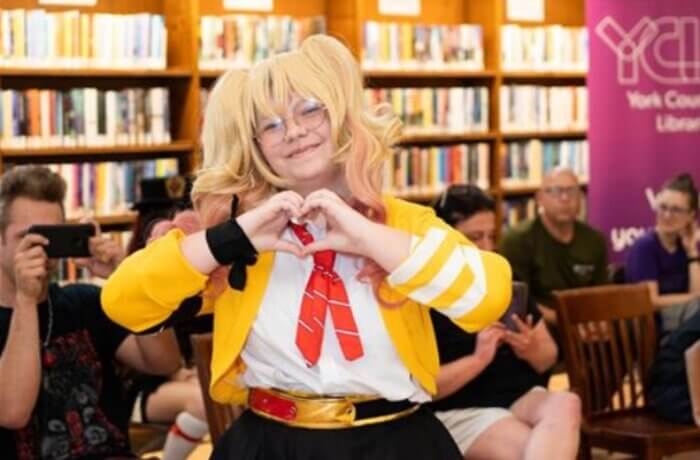 Girl wearing cosplay making a heart sign with her hands