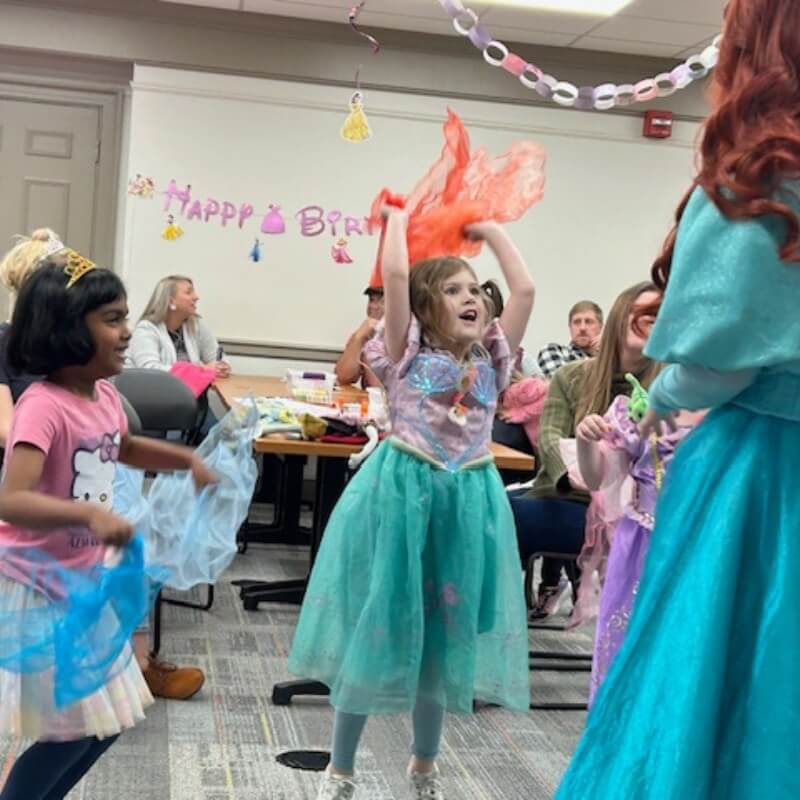 birthday girl jumping at party with mermaid princess