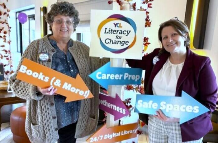 karen-and-daughter-holding-arrow-signs-for-literacy-for-change-v3