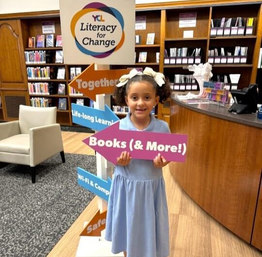 little-girl-holding-books-sign-for-literacy-for-change