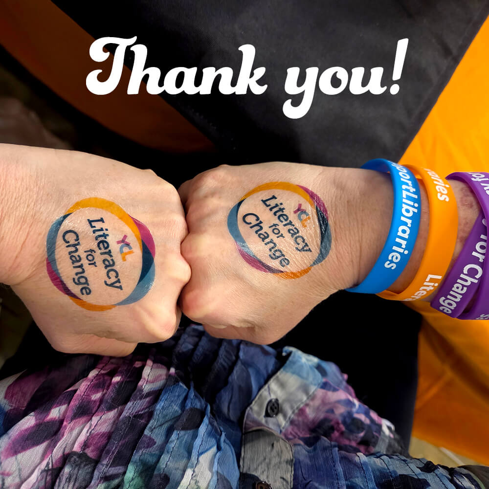Two hands with Literacy for Change temporary tattoos fist bumping